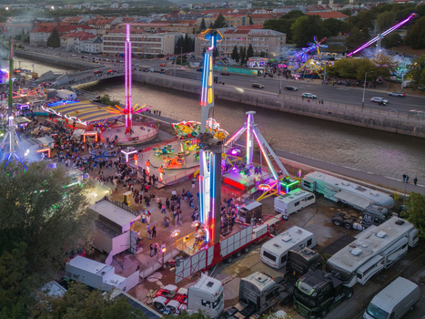 Aerial view of Radvansky jarmok with illuminated carnival rides crowds of people and trucks parked along the Hron river in Banska Bystrica Banskobystricky kraj Slovakia.