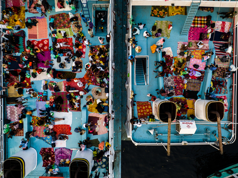 Aerial view of Sadarghat ferry deck crowded with passengers resting on colorful mats and blankets during a river journey in Dhaka Dhaka Division Bangladesh. Aerial view of Sadarghat ferry deck crowded with passengers resting on colorful mats and blankets during a river journey in Dhaka Dhaka Division Bangladesh.
