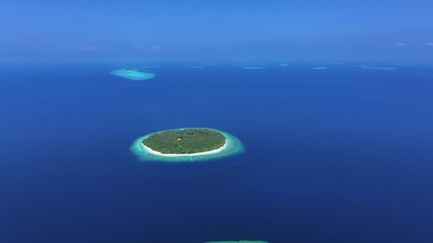 Aerial view of a tropical island atoll in the deep blue ocean Maldives. Aerial view of a tropical island atoll in the deep blue ocean Maldives.