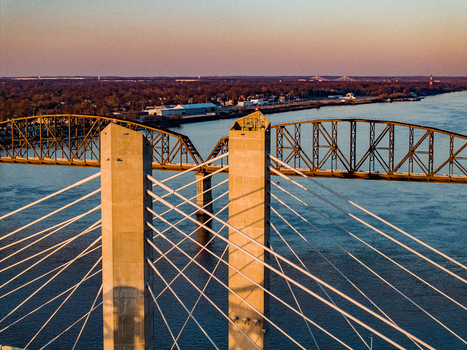 Aerial view of the Abraham Lincoln Bridge and Big Four Bridge spanning the Ohio River during a golden sunset in Louisville Kentucky United States. Aerial view of the Abraham Lincoln Bridge and Big Four Bridge spanning the Ohio River during a golden sunset in Louisville Kentucky United States.