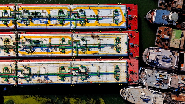 Aerial view of industrial barges docked at the port of Smederevo featuring red and white decks with green piping systems on the Danube River in Smederevo Podunavlje District Serbia.