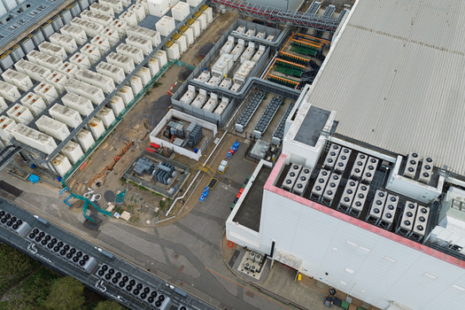 Aerial view of Data Center with rows of cooling units industrial HVAC systems and paved service areas in United Kingdom.