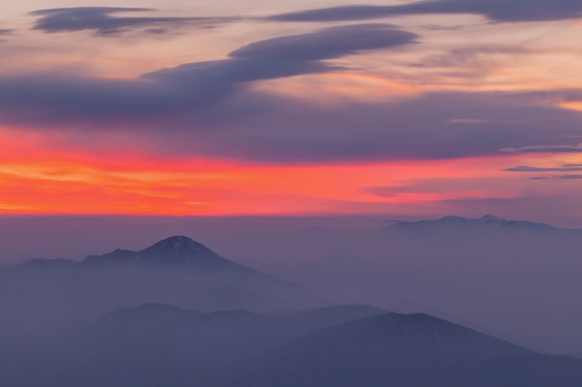Aerial view of Velky Choc mountain peak rising above a sea of mist during a vibrant sunset with orange and purple clouds in Vysny Kubin Zilina Region Slovakia. Aerial view of Velky Choc mountain peak rising above a sea of mist during a vibrant sunset with orange and purple clouds in Vysny Kubin Zilina Region Slovakia.
