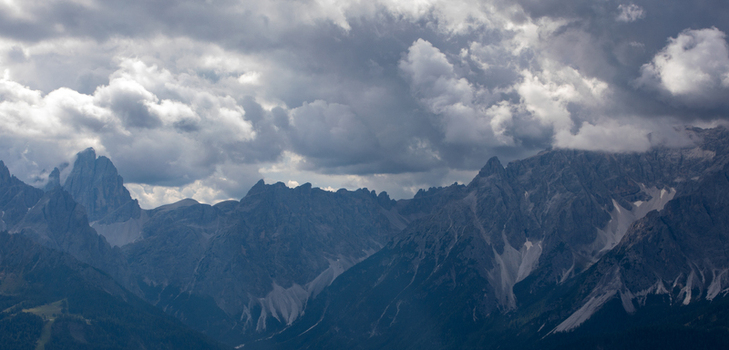 View of the jagged peaks of the Dolomites mountain range under a dramatic overcast sky with heavy grey clouds Rocca Pietore Veneto Italy. View of the jagged peaks of the Dolomites mountain range under a dramatic overcast sky with heavy grey clouds Rocca Pietore Veneto Italy.