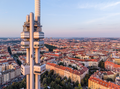 Aerial view of Zizkov Television Tower rising above the historic rooftops and urban landscape of Prague Prague Czechia.