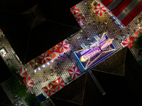 Aerial view of GOR Gelarsena Klaten Night Market with red and white striped tents and a brightly lit amusement ride at night in Kecamatan Klaten Utara Jawa Tengah Indonesia. Aerial view of GOR Gelarsena Klaten Night Market with red and white striped tents and a brightly lit amusement ride at night in Kecamatan Klaten Utara Jawa Tengah Indonesia.
