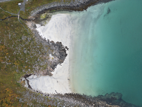 Aerial view of Rorvikstranda beach with white sand and turquoise water meeting the rocky coastline in Henningsvaer Nordland Norway.