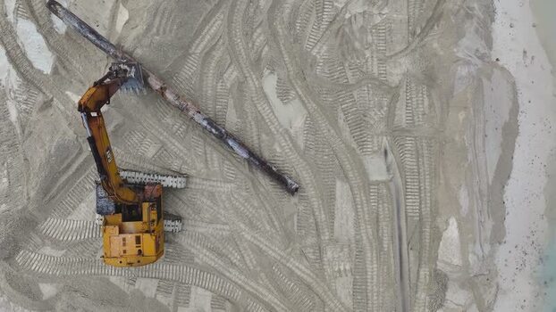 Aerial view of an excavator working on a sandy beach Maldives.