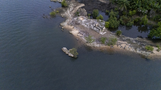 Aerial view of the historic ruins on the sandy shoreline surrounded by lush green vegetation and the dark waters of the lagoon in Badagry Lagos Nigeria. Aerial view of the historic ruins on the sandy shoreline surrounded by lush green vegetation and the dark waters of the lagoon in Badagry Lagos Nigeria.