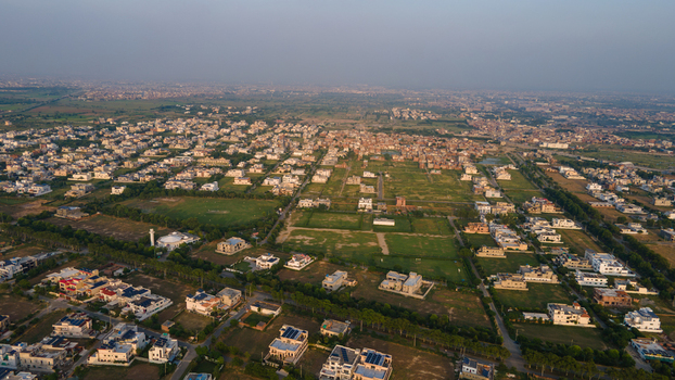 Aerial view of a residential neighborhood with houses green lawns and streets in Lahore Punjab Pakistan.