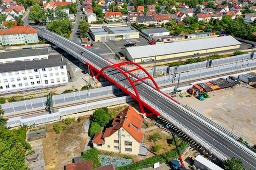 Aerial view of the Piastenbrucke with its red arches crossing over railway tracks and urban buildings in Forchheim Bayern Germany.