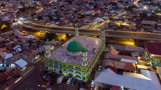 Aerial view of the Tamale Central Mosque with its green dome and minarets surrounded by urban buildings and roads in Tamale Northern Region Ghana. Aerial view of the Tamale Central Mosque with its green dome and minarets surrounded by urban buildings and roads in Tamale Northern Region Ghana.