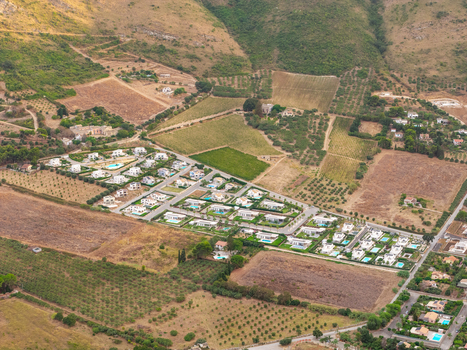 Aerial view of the residential area near Riserva Naturale Orientata dello Zingaro with white villas and swimming pools surrounded by olive groves in San Vito Lo Capo Sicilia Italy. Aerial view of the residential area near Riserva Naturale Orientata dello Zingaro with white villas and swimming pools surrounded by olive groves in San Vito Lo Capo Sicilia Italy.