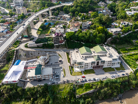 Aerial view of a modern building complex and a mosque situated near a large bridge and lush green hills in the city of Muzaffarabad Azad Kashmir Pakistan. Aerial view of a modern building complex and a mosque situated near a large bridge and lush green hills in the city of Muzaffarabad Azad Kashmir Pakistan.