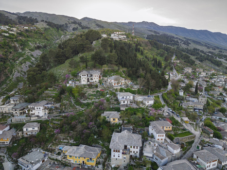 Aerial view of the historic stone houses and traditional architecture nestled on a hillside in Gjirokaster Gjirokaster County Albania. Aerial view of the historic stone houses and traditional architecture nestled on a hillside in Gjirokaster Gjirokaster County Albania.
