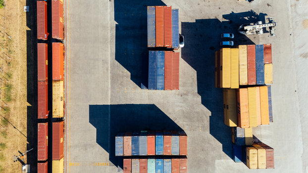 Indjija Serbia 24 August 2026 Aerial view of shipping containers stacked in a logistics yard with long shadows cast on the concrete ground.