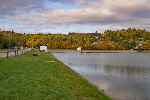View of Velka Richnava lake with vibrant autumn foliage and grassy banks Stiavnicke Bane Banska Bystrica Region Slovakia.