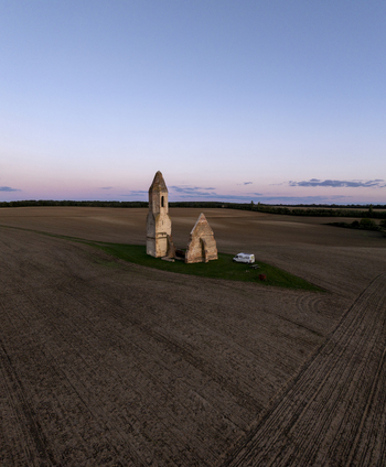 Aerial view of the historic Pusztatorony ruins standing in a vast plowed agricultural field at sunset in Somogyvamos Hungary. Aerial view of the historic Pusztatorony ruins standing in a vast plowed agricultural field at sunset in Somogyvamos Hungary.