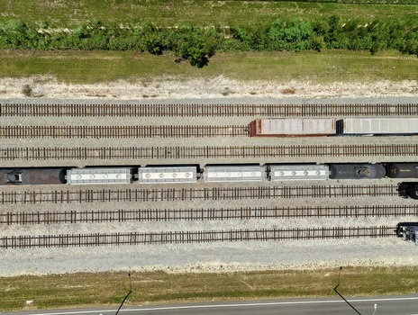 Aerial view of Georgia Pacific Palatka Operations rail yard with freight train cars on parallel tracks gravel ballast and green vegetation in Palatka Florida United States.