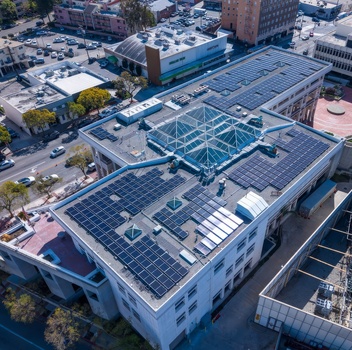 Aerial view of a commercial building featuring extensive rooftop solar panel arrays and a central glass skylight in an urban setting in Nashville Tennessee United States. Aerial view of a commercial building featuring extensive rooftop solar panel arrays and a central glass skylight in an urban setting in Nashville Tennessee United States.
