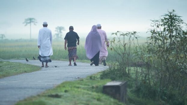 View of people walking on a rural road in Bogura Bangladesh.