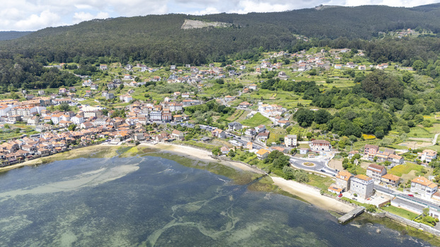 Aerial view of the historic coastal village featuring traditional stone houses along the shoreline and lush green hills Combarro Pontevedra Spain. Aerial view of the historic coastal village featuring traditional stone houses along the shoreline and lush green hills Combarro Pontevedra Spain.