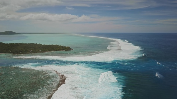 Aerial view of the turquoise lagoon and coral reef surrounding the lush island of Moorea with crashing waves meeting the deep blue ocean in Moorea Maiao Windward Islands French Polynesia. Aerial view of the turquoise lagoon and coral reef surrounding the lush island of Moorea with crashing waves meeting the deep blue ocean in Moorea Maiao Windward Islands French Polynesia.