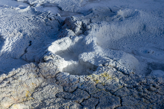 View of Geisers Sol de la Manana featuring bubbling mud pools steaming vents and cracked volcanic earth in Sur Lipez Potosi Department Bolivia. View of Geisers Sol de la Manana featuring bubbling mud pools steaming vents and cracked volcanic earth in Sur Lipez Potosi Department Bolivia.