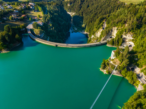 Aerial view of the Barrage de Rossens dam spanning the turquoise waters of Lac de la Gruyere surrounded by forests and tunnels near Pont la Ville Fribourg Switzerland.