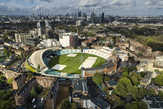 Aerial view of The Kia Oval cricket ground surrounded by urban residential buildings and the London skyline in London England United Kingdom.