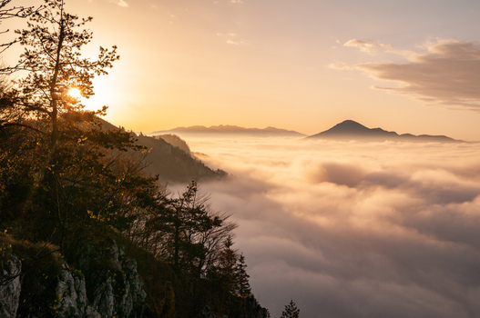 Aerial view of Sip in Mala Fatra mountain range rising above a sea of clouds at sunrise with golden light illuminating the forest and rocky terrain Stankovany Zilina Region Slovakia. Aerial view of Sip in Mala Fatra mountain range rising above a sea of clouds at sunrise with golden light illuminating the forest and rocky terrain Stankovany Zilina Region Slovakia.