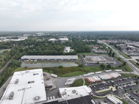 Aerial view of industrial warehouses and distribution centers with parked semi trucks and a small pond in Indianapolis Indiana United States. Aerial view of industrial warehouses and distribution centers with parked semi trucks and a small pond in Indianapolis Indiana United States.