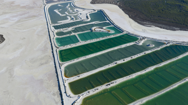 Aerial view of salt evaporation ponds with vibrant green and turquoise water separated by white salt dikes in the remote landscape of Kalbarri Western Australia Australia. Aerial view of salt evaporation ponds with vibrant green and turquoise water separated by white salt dikes in the remote landscape of Kalbarri Western Australia Australia.