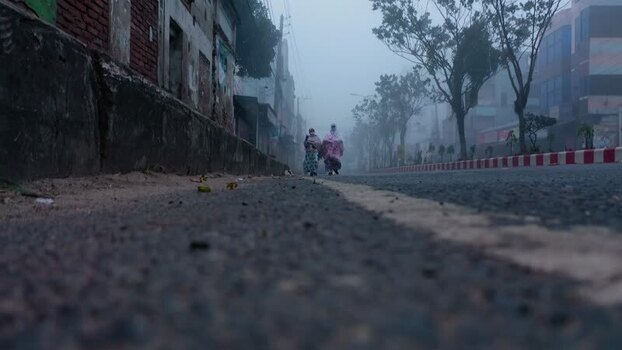 View of people walking on a foggy street in Bogura Bangladesh. View of people walking on a foggy street in Bogura Bangladesh.