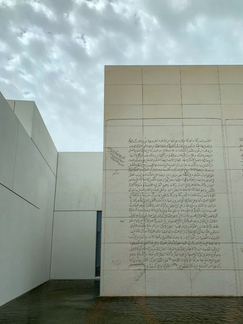 View of modern architectural walls with intricate Arabic calligraphy engravings under an overcast sky in Dubai Dubai United Arab Emirates. View of modern architectural walls with intricate Arabic calligraphy engravings under an overcast sky in Dubai Dubai United Arab Emirates.
