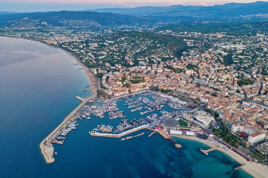 Aerial view of the harbor with numerous yachts and boats docked surrounded by the coastal city sandy beaches and the Mediterranean Sea in Cannes Provence Alpes Cote d Azur France. Aerial view of the harbor with numerous yachts and boats docked surrounded by the coastal city sandy beaches and the Mediterranean Sea in Cannes Provence Alpes Cote d Azur France.