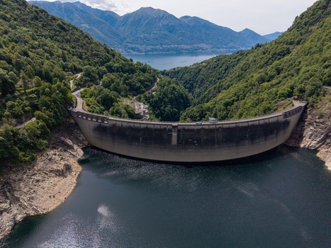 Aerial view of the Verzasca Dam surrounded by lush green mountains and the calm waters of the reservoir in Gordola Ticino Switzerland. Aerial view of the Verzasca Dam surrounded by lush green mountains and the calm waters of the reservoir in Gordola Ticino Switzerland.