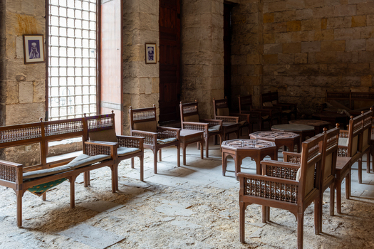 View of the historic interior of the Sultan al Ghuri Complex featuring traditional wooden furniture and ancient stone walls El Darb El Ahmar Cairo Governorate Egypt. View of the historic interior of the Sultan al Ghuri Complex featuring traditional wooden furniture and ancient stone walls El Darb El Ahmar Cairo Governorate Egypt.