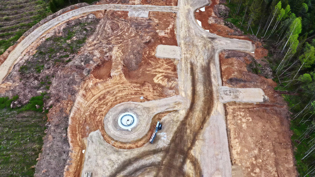 Aerial view of wind turbine foundation construction in a cleared forest area with dirt roads and heavy machinery in Latvia. Aerial view of wind turbine foundation construction in a cleared forest area with dirt roads and heavy machinery in Latvia.