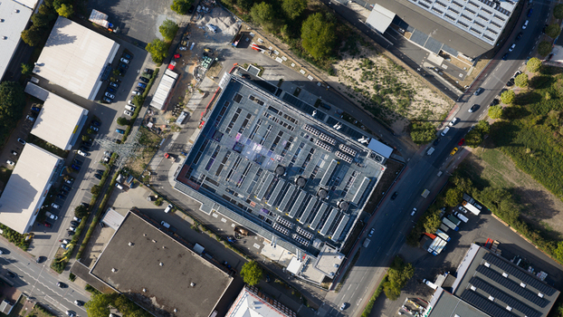 Aerial view of Sossenheim datacenters featuring a large industrial building with rooftop HVAC units surrounded by parking lots and roads in Frankfurt am Main Hessen Germany. Aerial view of Sossenheim datacenters featuring a large industrial building with rooftop HVAC units surrounded by parking lots and roads in Frankfurt am Main Hessen Germany.