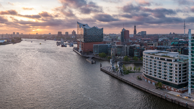 Aerial view of the Elbphilharmonie and Strandkai district overlooking the Elbe river under a dramatic sunset sky with soft clouds in Hamburg Hamburg Germany. Aerial view of the Elbphilharmonie and Strandkai district overlooking the Elbe river under a dramatic sunset sky with soft clouds in Hamburg Hamburg Germany.