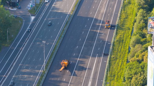Waardenburg Netherlands 09 May 2026 Aerial view of road maintenance vehicles working on a multi lane highway surrounded by lush green trees. Waardenburg Netherlands 09 May 2026 Aerial view of road maintenance vehicles working on a multi lane highway surrounded by lush green trees.