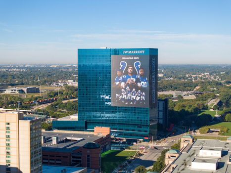 Indianapolis United States 27 September 2026 Aerial view of the JW Marriott Indianapolis featuring a large Indianapolis Colts mural on its blue glass facade surrounded by urban infrastructure. Indianapolis United States 27 September 2026 Aerial view of the JW Marriott Indianapolis featuring a large Indianapolis Colts mural on its blue glass facade surrounded by urban infrastructure.