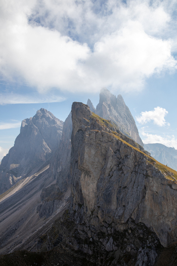 View of the jagged peaks of the Dolomites mountain range under a blue sky with white clouds over Rocca Pietore Veneto Italy. View of the jagged peaks of the Dolomites mountain range under a blue sky with white clouds over Rocca Pietore Veneto Italy.