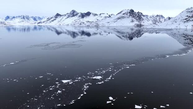 Aerial view of snow capped mountains and icy fjord Greenland. Aerial view of snow capped mountains and icy fjord Greenland.