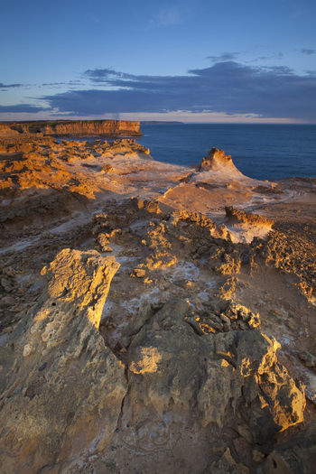 View of rugged limestone rock formations and coastal cliffs at Twelve Apostles Marine National Park during golden hour in Australia. View of rugged limestone rock formations and coastal cliffs at Twelve Apostles Marine National Park during golden hour in Australia.