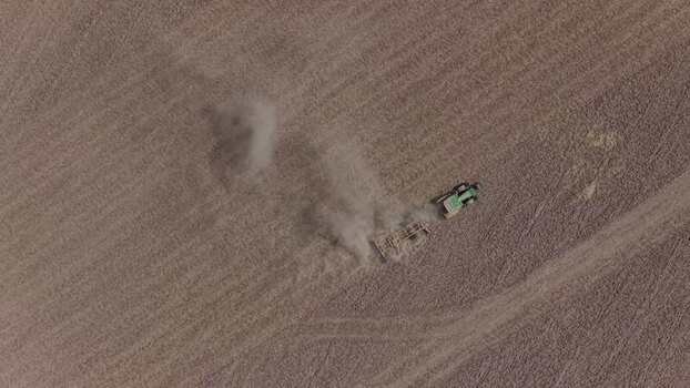 Aerial view of a tractor plowing a dry field Portugal. Aerial view of a tractor plowing a dry field Portugal.