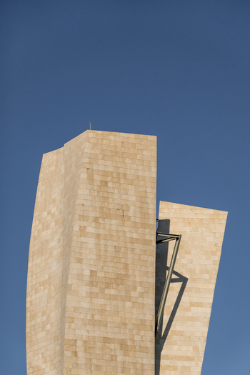 View of the curved limestone towers of the Guggenheim Museum Bilbao under a clear blue sky in Bilbao Euskadi Spain. View of the curved limestone towers of the Guggenheim Museum Bilbao under a clear blue sky in Bilbao Euskadi Spain.