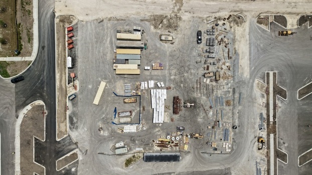Aerial view of Foundry Lane construction site with shipping containers building materials and heavy machinery on a dirt lot World Golf Village Florida United States.