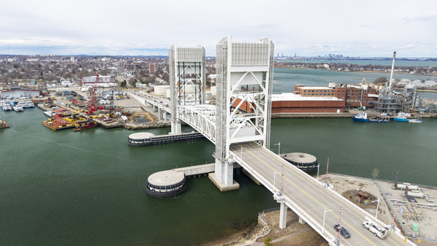 Aerial view of the iconic Fore River Bridge cutting through the waters its stark white structure contrasting against the muted greens and blues Quincy Massachusetts United States.